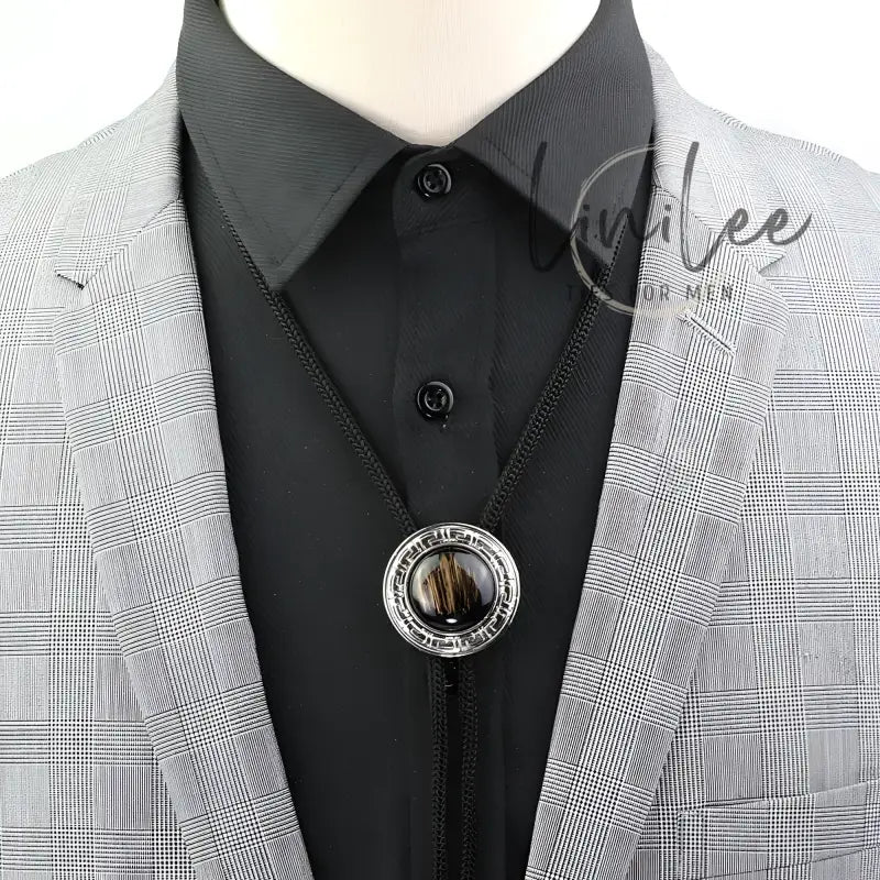 Black bolo tie with silver circular pendant.